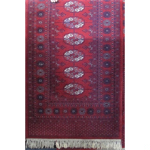 2390 - Pair of long Bokhara runners with typical geometric medallion decoration upon a red ground, each 330... 