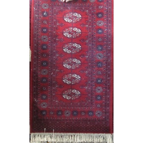 2390 - Pair of long Bokhara runners with typical geometric medallion decoration upon a red ground, each 330... 