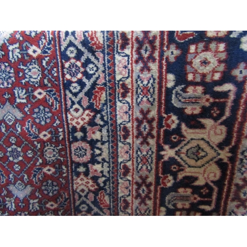 2396 - A Belgian carpet with typical scrolled foliate decoration upon a red ground, 300 x 200cm