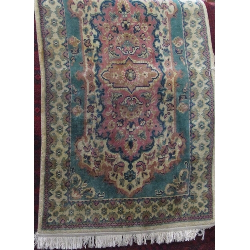 2400 - Full pile rug with washed pink and green decoration upon a cream ground, 150 x 90cm