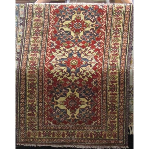 2405 - Persian three medallion rug upon a red ground, together with a further three medallion rug on a crea... 