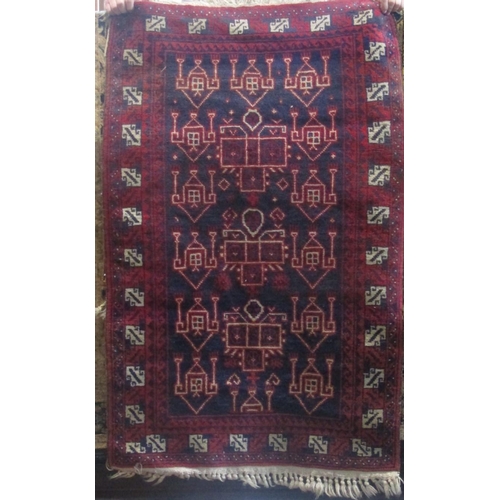 2418 - A Persian rug with white and red medallions upon a navy blue ground, 140 x 85cm