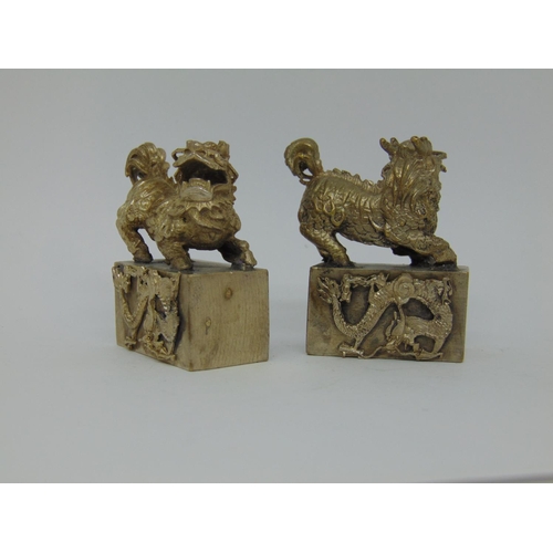 1126 - Chinese spelter napkin ring and a pair of Chinese medal seals with temple lion mounts