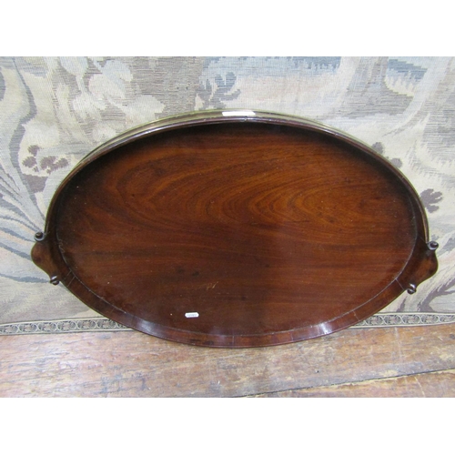 2175 - A Georgian mahogany serving tray of oval form, with raised gallery border, brass banding and with sc... 