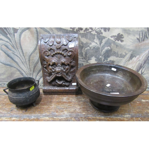 2195 - An antique turned stem bowl, a 19th century iron cauldron and a carved oak boss, with grotesque mask... 
