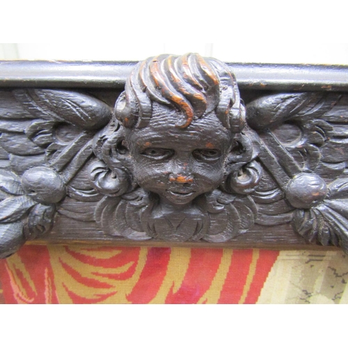 2137 - A Victorian carved oak fire screen with applied trailing floral rams mask, cherub and other panels (... 