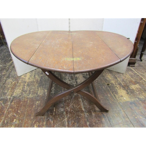2182 - An oak coaching table in the manner of Heals, with circular folding top raised on a X shaped folding... 