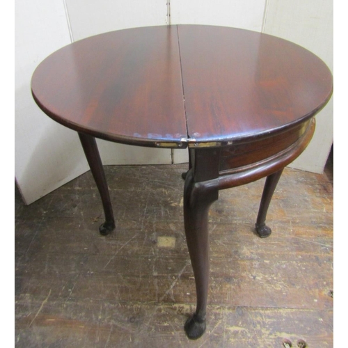 2186 - A Georgian mahogany demi-lune fold-over top tea table with enclosed centre, raised on four carved ho... 
