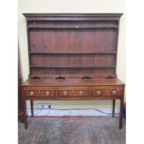 2194 - A Georgian oak Welsh dresser and plate rack, the base enclosed by three frieze drawers, crossbanded ... 