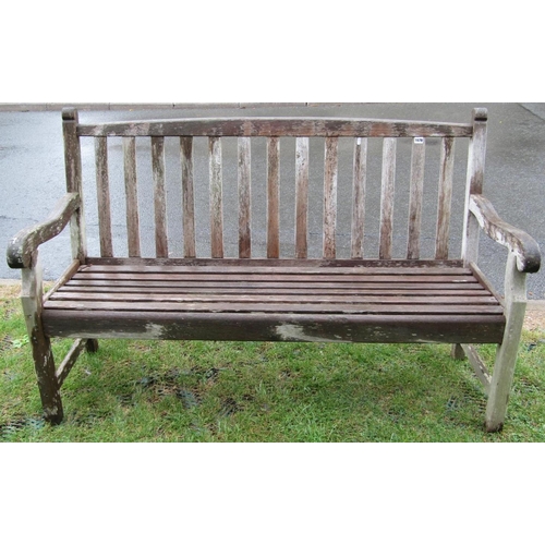 1678 - A weathered teak garden bench with slatted seat, back and scrolled arms, 5ft long