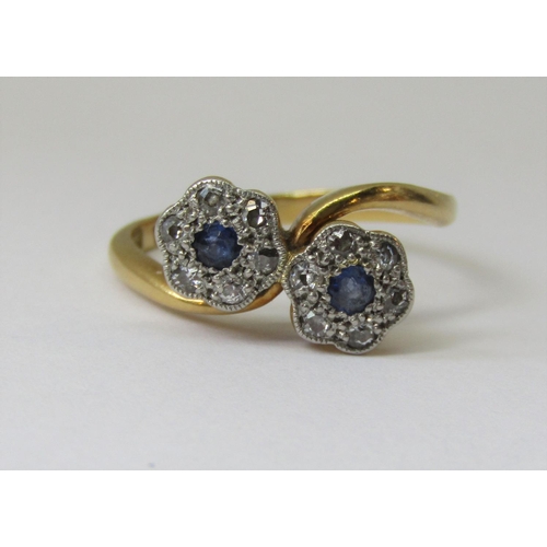 864 - 18ct daisy crossover ring set with sapphires and diamonds, size K/L, 3.2g