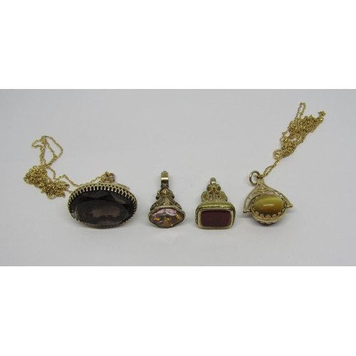 950 - Collection of fobs comprising a swivel example set with tigers eye and cats eye, hung on an associat... 