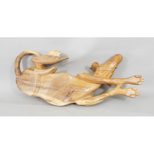 65 - A carved hardwood figure of a recumbent hound, 56cm long