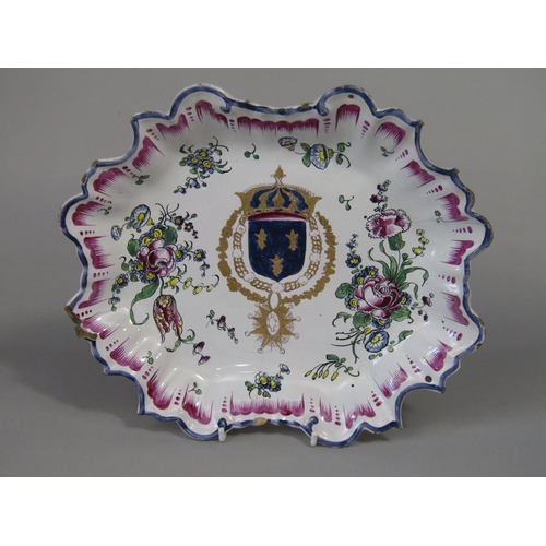 1077 - A 19th century continental tin glazed earthenware dish with polychrome painted and gilded crest with... 