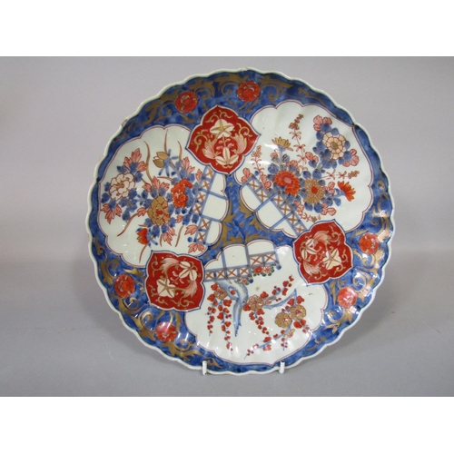 1085 - A 19th century oriental charger with shaped rim and painted and gilded imari type decoration incorpo... 