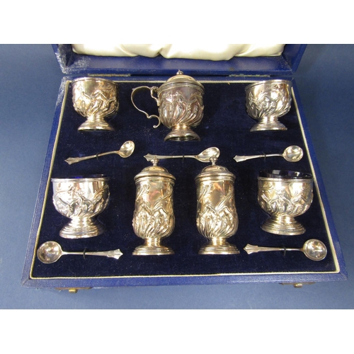 1262 - Good quality cased seven piece silver table cruets with half fluted and floral embossed decoration, ... 