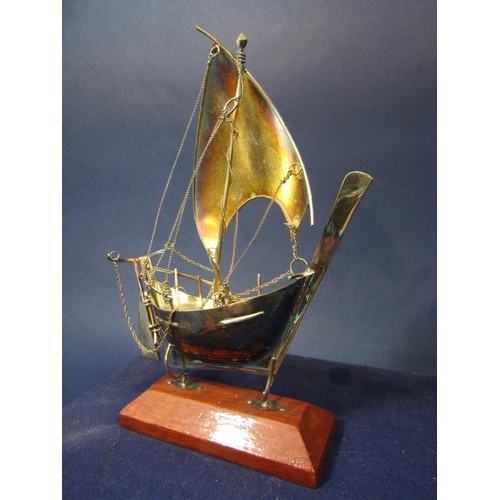 1281 - Cased white metal galleon with wooden plinth stand, 2 oz approx