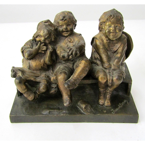 394 - Juan, Clara.  Cast bronze group of 3 amused and contented children sitting upon a bench. 15cm long