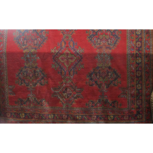 1803 - Turkish carpet with blue and green medallions upon a red ground, 320 x 250cm