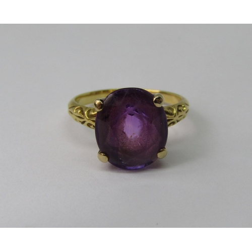 1307 - Amethyst dress ring in four prong setting, in unmarked yellow metal with scrolled shoulders, size K,... 