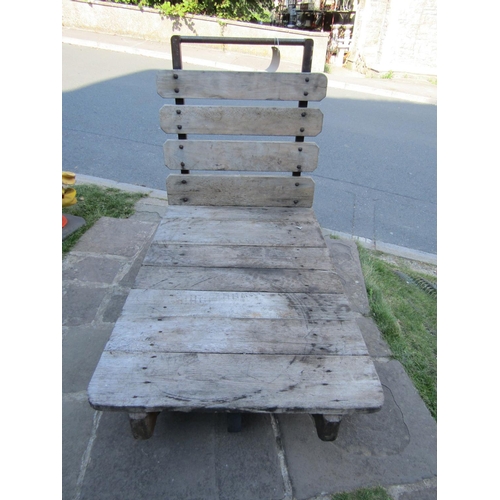 2068 - A vintage industrial platform trolley with weathered timber boarded bed, steel handle and four fixed... 