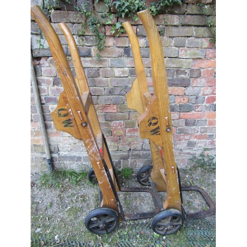 2070 - A pair of vintage heavy duty sack trucks with ashwood shafts united by square through jointed splats... 