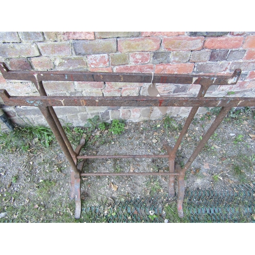 2071 - A pair of old iron work trestles with simple swept supports, supporting an associated stripped pine ... 