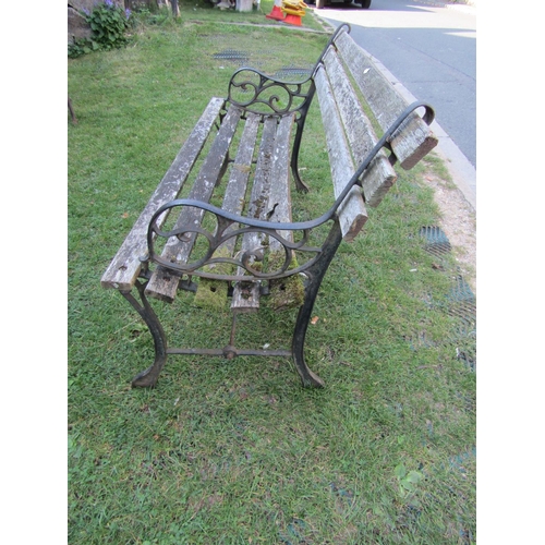 2072b - A two seat garden bench with pierced cast iron ends and weathered timber lathes (AF), 4ft wide