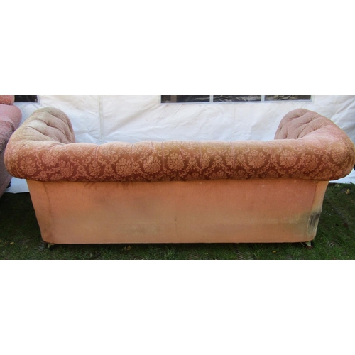 2048 - A two seat Chesterfield sofa, with pink ground repeating floral patterned upholstered finish and but... 