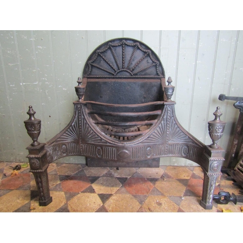 2081 - An Adam style cast iron and steel fire grate with serpentine front, bowed basket and decorative clas... 