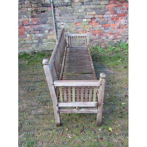 2038 - A weathered teak garden bench with slatted back and arms beneath faceted finials (AF), 6ft long