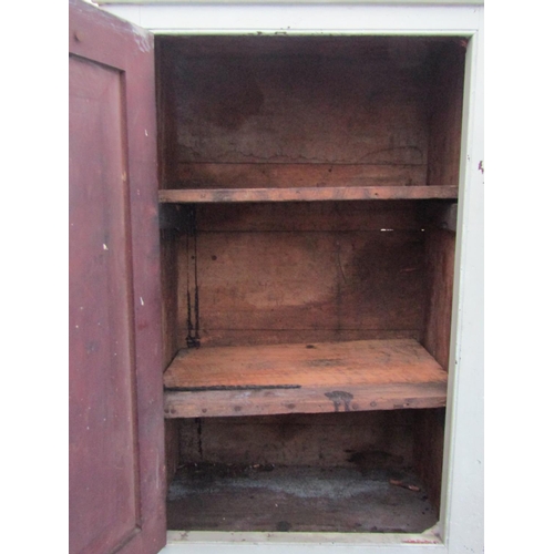 2054 - An old rustic painted pine cupboard enclosed by a rectangular panelled door, 49 cm wide x 77 cm high... 