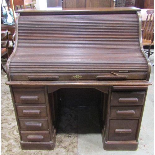 2273 - A twin pedestal oak roll top desk, the serpentine roll enclosing a fitted interior over the usual ar... 