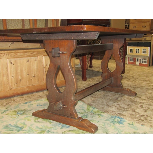 2243 - A reproduction oak refectory table, the rectangular top raised on a pair of lyre shaped and sledge s... 