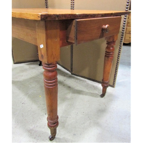 2260 - A stained pine kitchen table of rectangular form with end frieze drawer raised on ring turned and ta... 