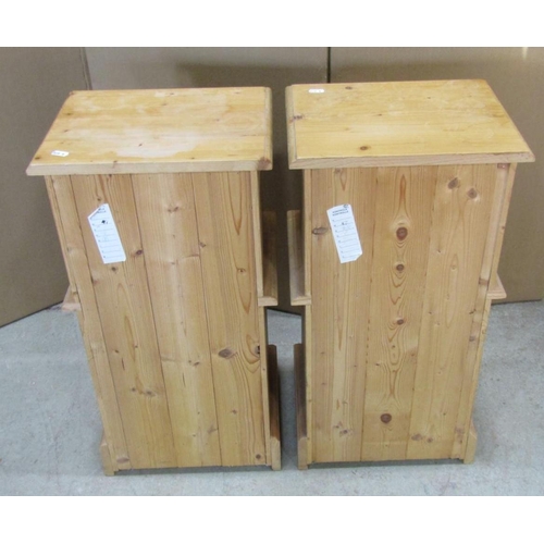 2278 - A matched pair of stripped pine bedside cupboards each enclosed by a fielded panelled door beneath a... 