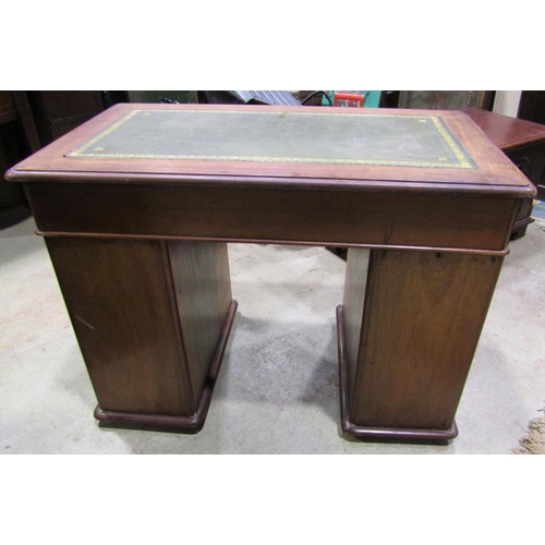 2299 - A small Victorian mahogany kneehole twin pedestal desk with inset green leather panelled top over an... 