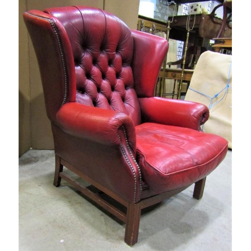 2398 - A contemporary Georgian style red leather upholstered wing armchair with button back and loose squab... 