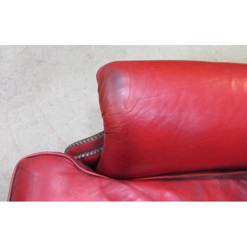 2398 - A contemporary Georgian style red leather upholstered wing armchair with button back and loose squab... 