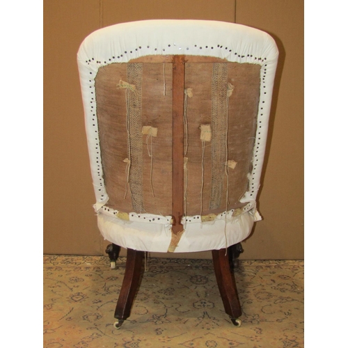 2311 - A Victorian nursing chair, simply upholstered in white calico and raised on scrolled cabriole forele... 