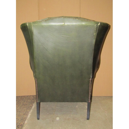 2319 - A pair of  Georgian style faux green leather wing armchairs with button backs, loose squab seat cush... 