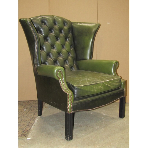 2319 - A pair of  Georgian style faux green leather wing armchairs with button backs, loose squab seat cush... 