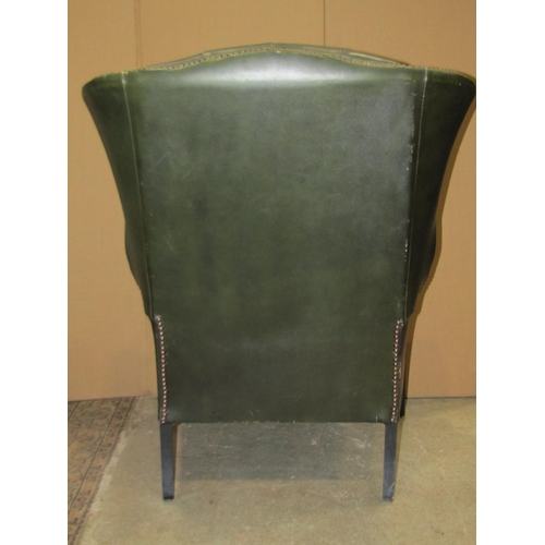 2319 - A pair of  Georgian style faux green leather wing armchairs with button backs, loose squab seat cush... 