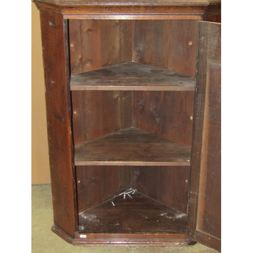 2384 - A Georgian oak hanging corner cupboard enclosed by a fielded arched panelled door with polished H sh... 