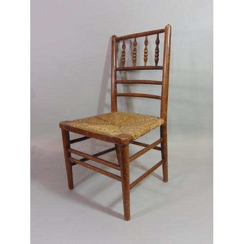 533 - An Arts & Crafts child's chair with turned spindle back over a rush seat