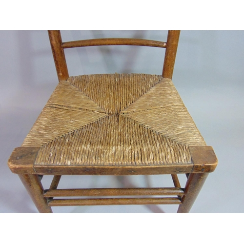 533 - An Arts & Crafts child's chair with turned spindle back over a rush seat