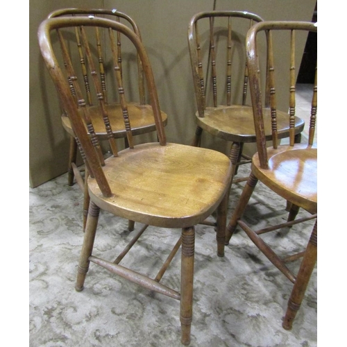 2365 - A set of four stained beechwood hoop back dining chairs with turned spindle backs over solid seats r... 