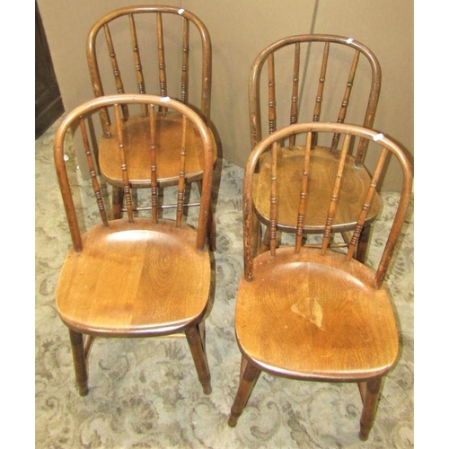 2365 - A set of four stained beechwood hoop back dining chairs with turned spindle backs over solid seats r... 