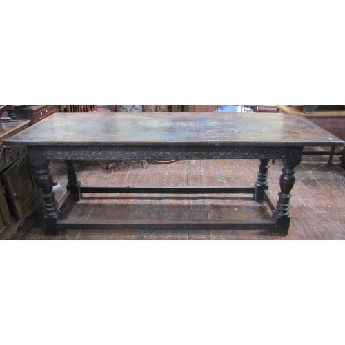 2654 - An antique oak refectory table, the plank top with cleated ends over a carved frieze (to all sides),... 