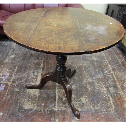 2655 - A Georgian oak snap top table the circular top 80 cm in diameter, raised on a turned pillar and shap... 